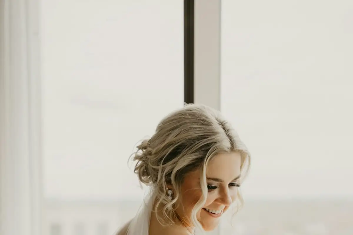 A bride in her dress looking out of a window